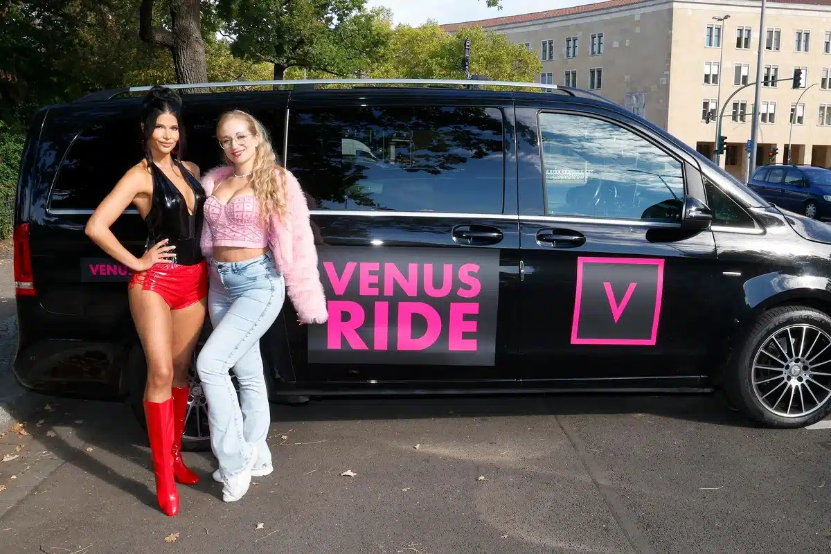 Micaela Schäfer und Mika Nox vor dem schwarzen VENUS-Ride-Van am ehemaligen Flughafen Tempelhof